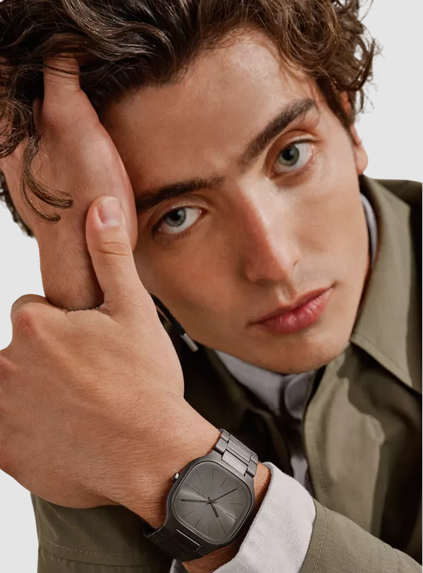 Person, die eine stilvolle goldene Freizeit-Armbanduhr mit Lederarmband trägt