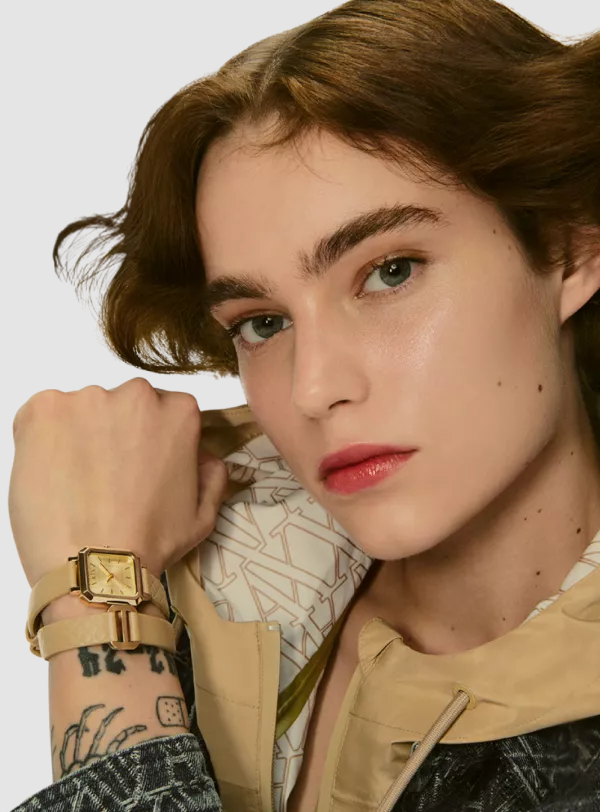 Frau mit einer eleganten goldenen Armbanduhr mit Edelstahlarmband