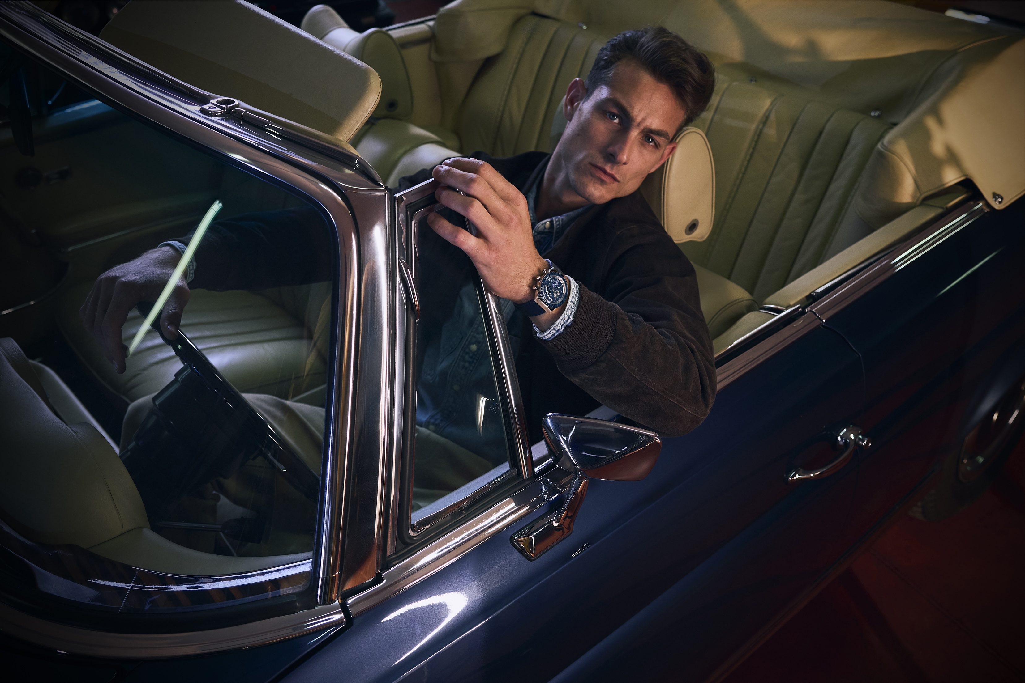 Model wearing watch, leaning on car door